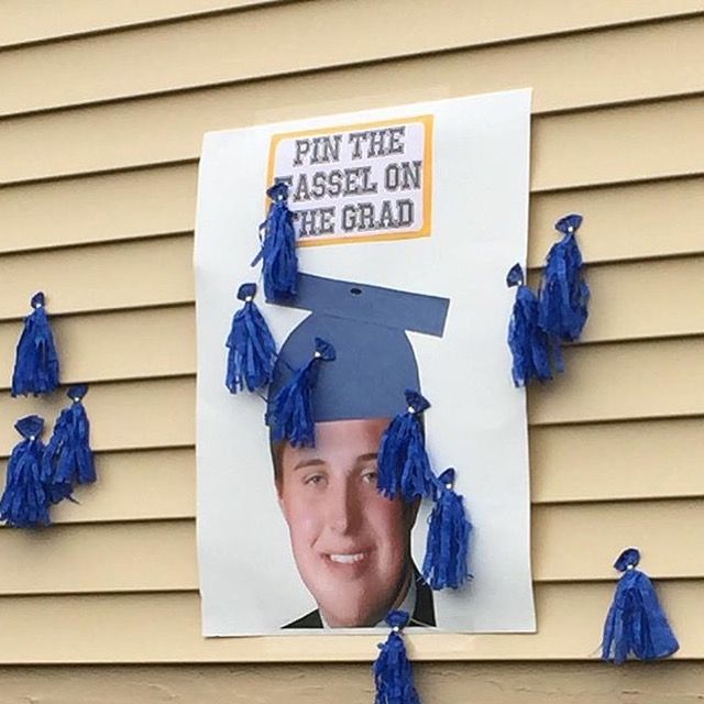 a graduation photo hanging on the side of a building with blue tassels around it