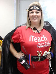 a woman wearing a red shirt and black cape with scissors in her hands, holding a pair of scissors