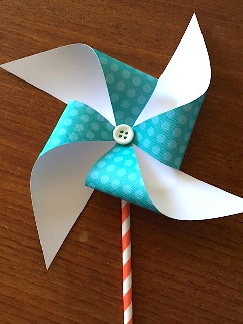 a pinwheel on a wooden table with a striped stick