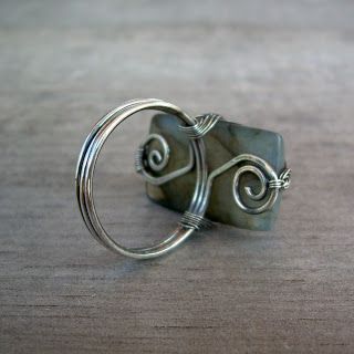 a wire wrapped ring sitting on top of a wooden table