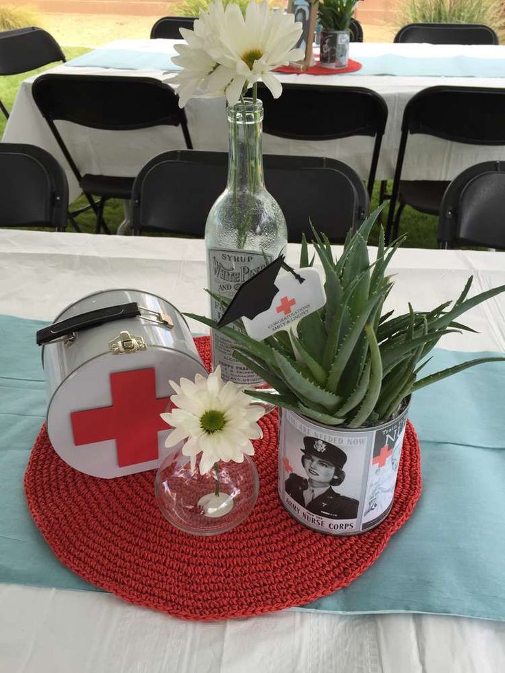 an arrangement of flowers and medical items sits on a table with chairs in the background