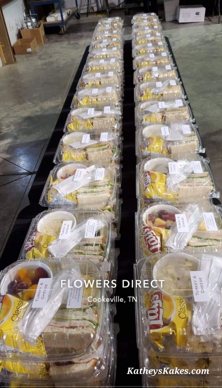 plastic containers filled with food sitting on top of a conveyor belt