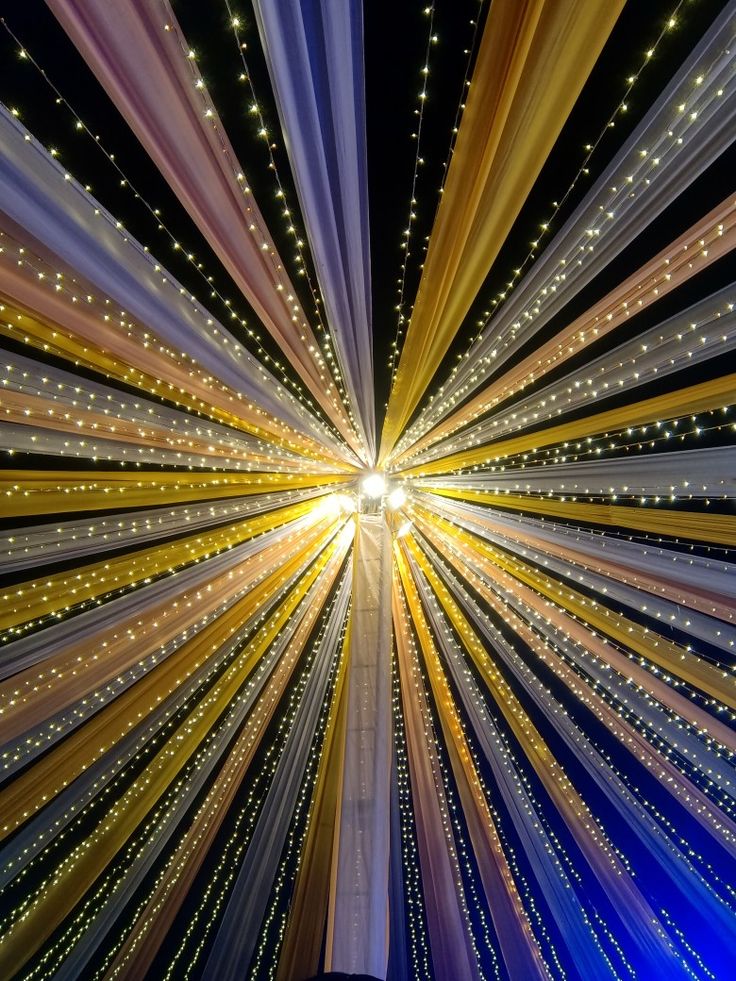 the ceiling is decorated with lights and streamers in blue, yellow and white colors