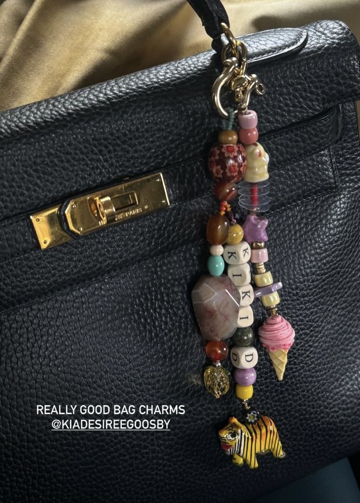 a handbag with charms attached to it