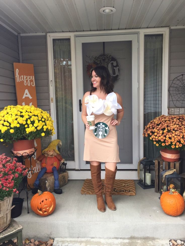 a woman standing in front of a door with pumpkins and other decorations around her