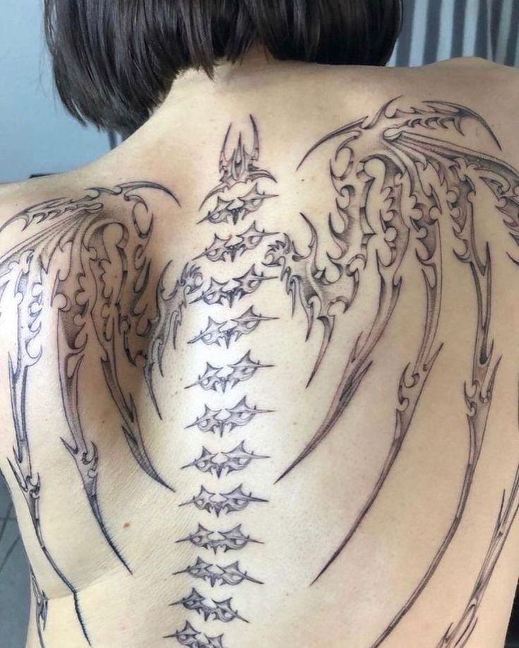 the back of a woman with tattoos on her body