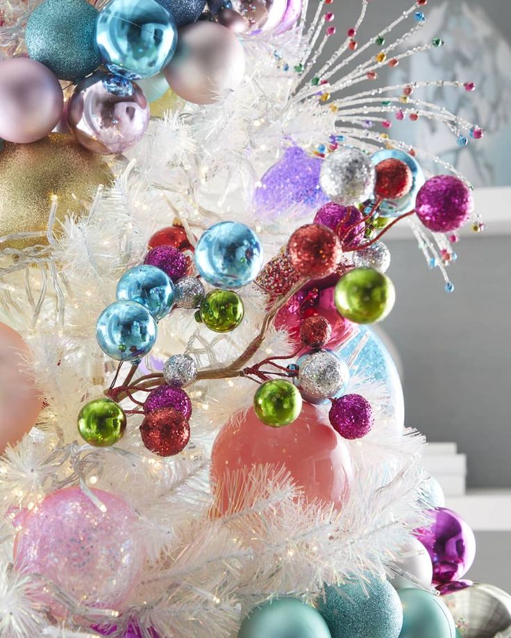 a white christmas tree decorated with colorful ornaments