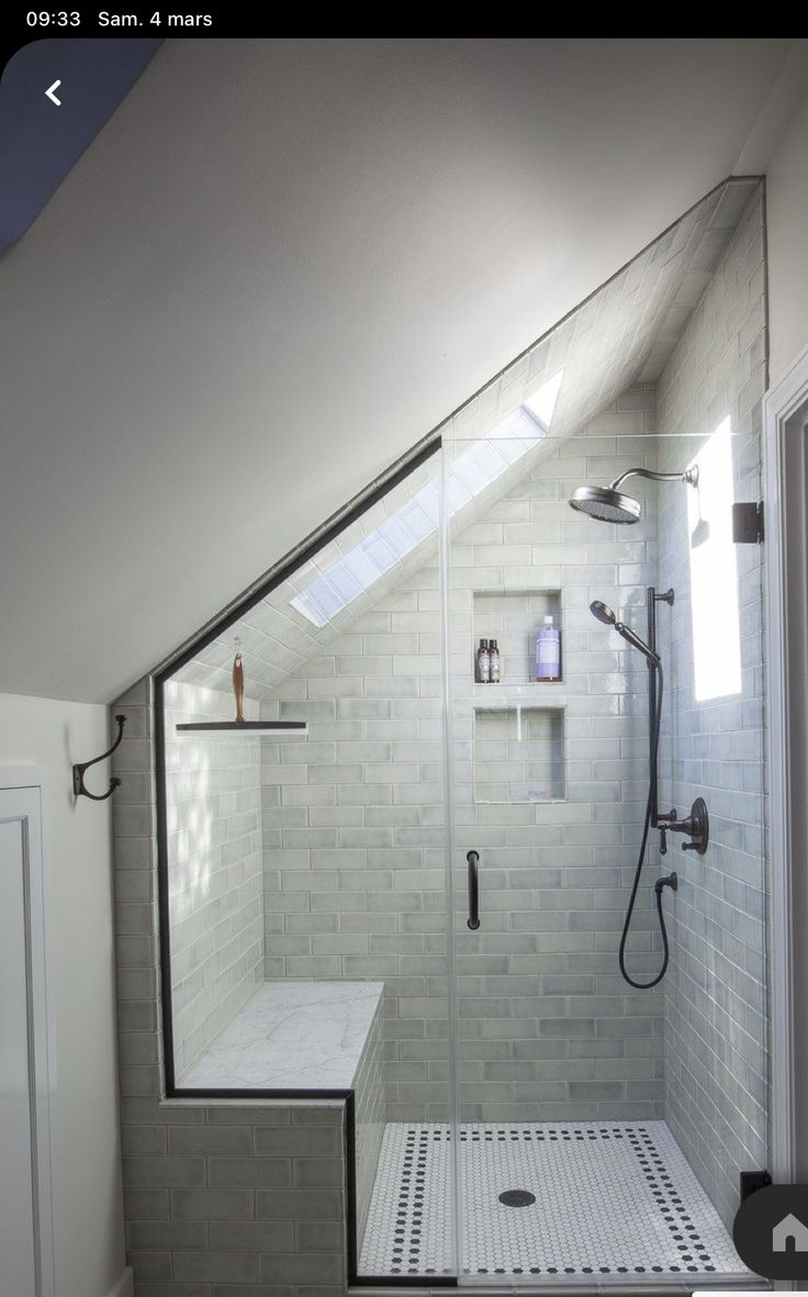 a walk in shower sitting under a window next to a white tiled wall and floor