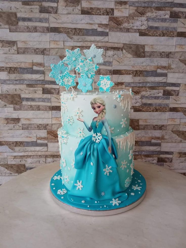 a frozen princess cake with blue frosting and snowflakes