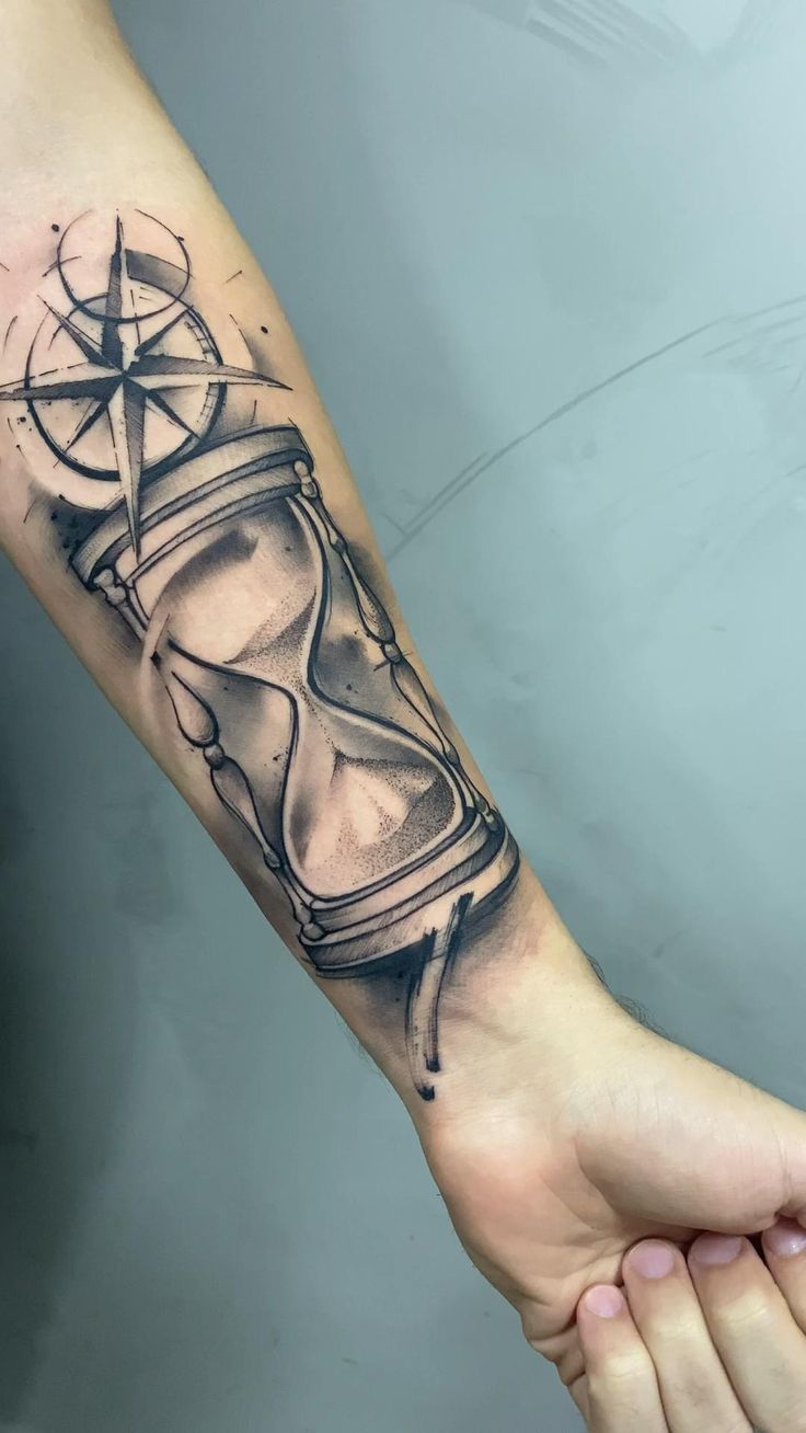 a person with a tattoo on their arm is holding an hourglass in his hand