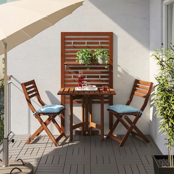 an outdoor table with two chairs and umbrella