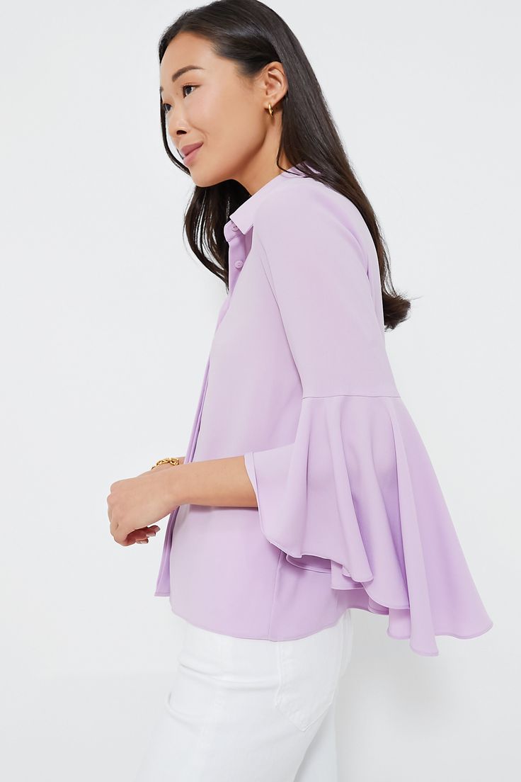 Classic meets cool with the Lilac Norah Bell Sleeve Blouse. Timeless, tried and true details like a crisp collar and a concealed button front placket bring a polished feel — then the addition of those showstopping ruffle cuffs and a silky texture takes the silhouette up a notch and makes it feel exciting and new. Wearable as ever, this top looks perfect with trousers and loafers for a day in the office, or with denim and a tote for weekend wear! Collared neckline Three-quarter length sleeves Sta Semi-formal Collared Tops For Spring, Formal Solid Blouse With Placket, Formal Blouse With Placket, Chic Solid Color Collared Shirt, Chic Solid Collared Shirt, Fitted Solid Color Blouse With Placket, Spring Blouse With Spread Collar And Buttons, Spring Blouse With Buttons And Spread Collar, Solid Color Blouse With Spread Collar For Spring