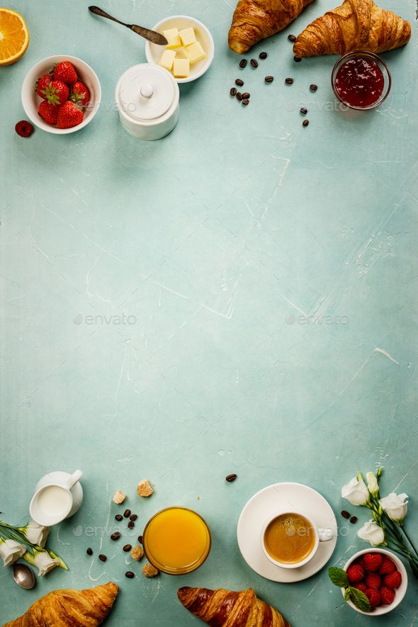 croissants, orange juice and other breakfast foods arranged on a blue background