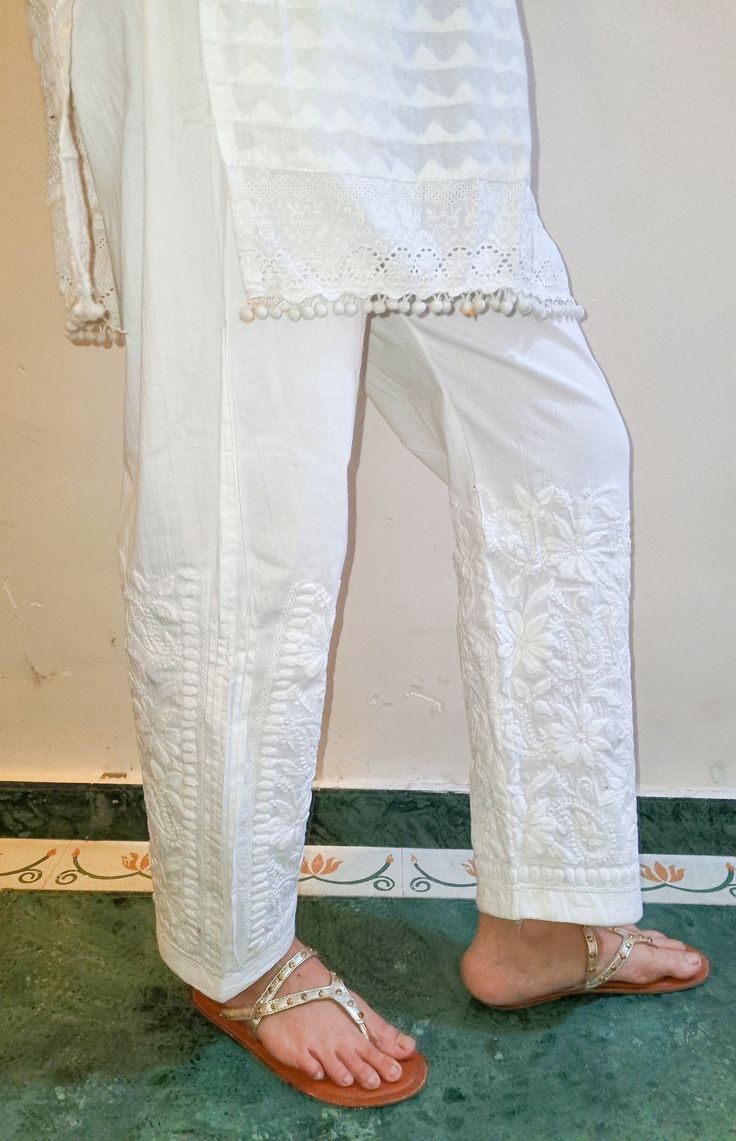 Cotton pants with pleated inserts and embroidered in chikankari. Pockets. Length - Inseam - Sizes - S - fits 36 upto 40 waist M - fits 38 upto 42 waist L - fits 40 upto 44 waist XL - fits 42 upto 46 waist Elegant White Pants With Resham Embroidery, Spring Wide Leg Bottoms With Resham Embroidery, Spring Straight Pants With Resham Embroidery, Elegant Wide-leg Bottoms With Chikankari Embroidery, Straight Pants With Resham Embroidery For Spring, White Chikankari Embroidery Sets With Straight Pants, White Floral Embroidery Pants For Festive Season, White Ankle-length Pants With Floral Embroidery, Festive White Pants With Floral Embroidery