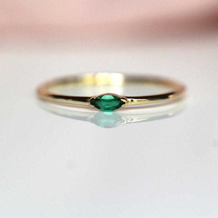 A dainty marquise emerald is at the center of our "Wink" ring, giving you just a little wink of sparkle!   - Marquise stone measures 4mm x 2mm - Handcrafted out of solid 10K or 14K gold - Round band measures 1.2mm in width - This emerald is lab made Processing Times -  Current processing time is 1 - 3 weeks.  Each Item is handmade to order with love and care! In Stock Items -  Contact Liesel Love with any rush order questions, or to see if we have anything ready made and in stock.  Returns -  Li Marquise Birthstone Ring In Fine Jewelry Style, Emerald Jewelry Marquise Cut For May Birthstone, Fine Jewelry Marquise May Birthstone Ring, Fine Jewelry With Marquise Cut May Birthstone, Fine Jewelry Marquise Emerald Promise Ring, Gift Jewelry Marquise Cut May Birthstone, Marquise Cut May Birthstone Jewelry Gift, May Birthstone Jewelry Gift In Marquise Cut, Marquise Cut Emerald Jewelry For May Birthstone