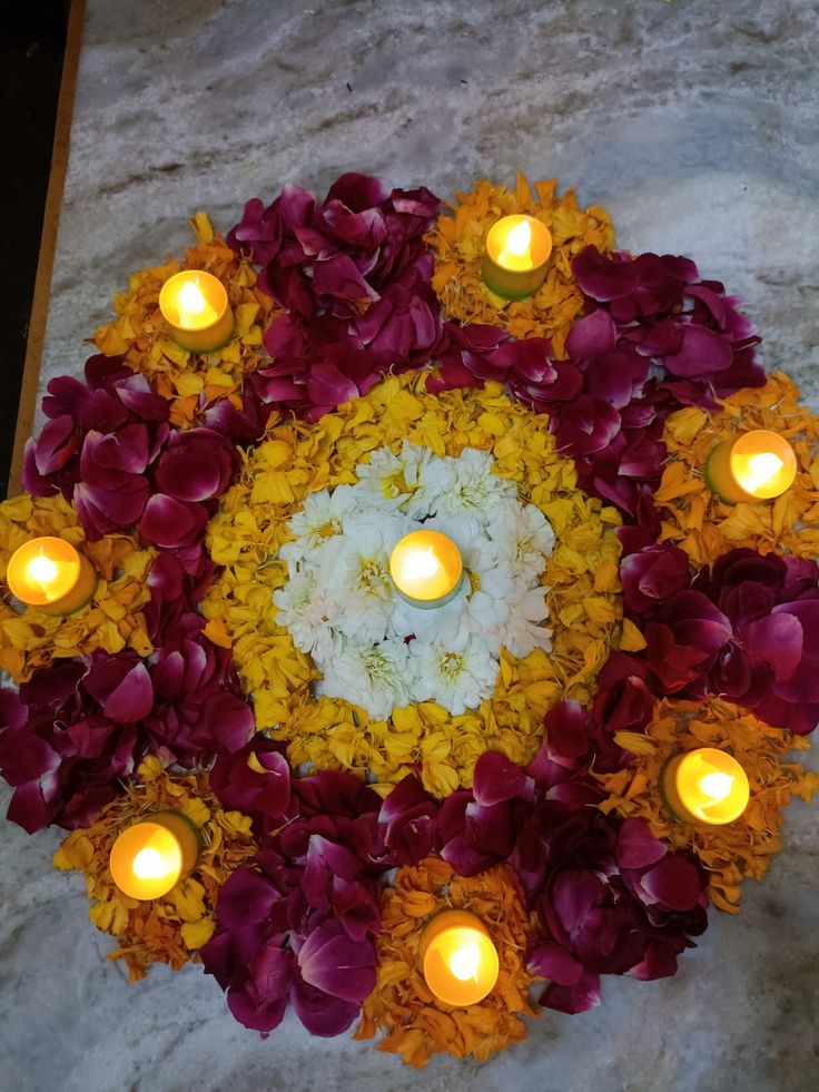 flowers and candles are arranged in a circular arrangement