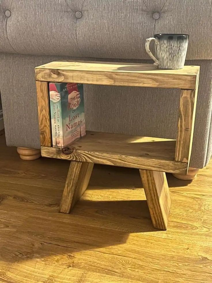 a wooden table sitting on top of a hard wood floor next to a gray couch