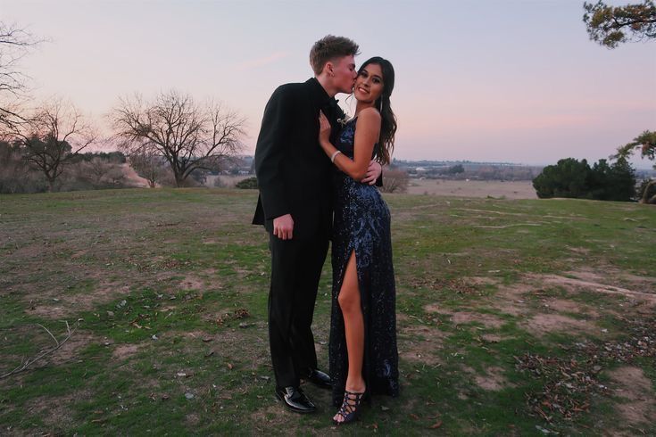 a man and woman standing next to each other in a field