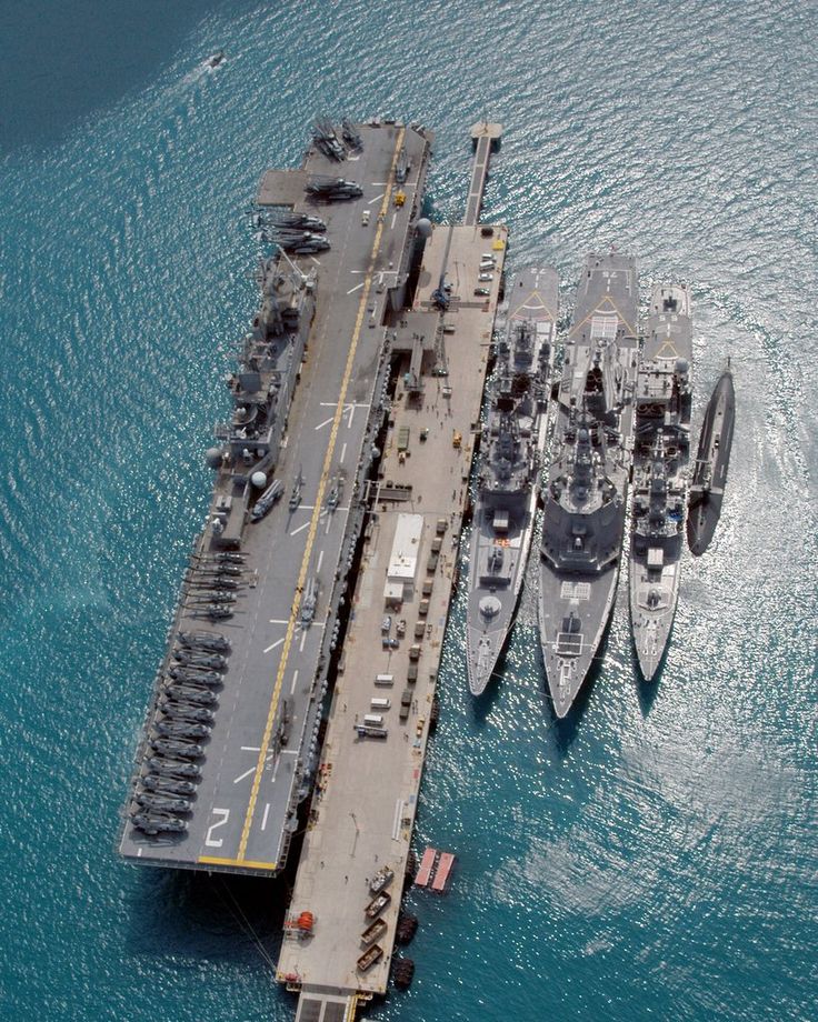 an aerial view of two ships in the water and one boat is docked on it's side