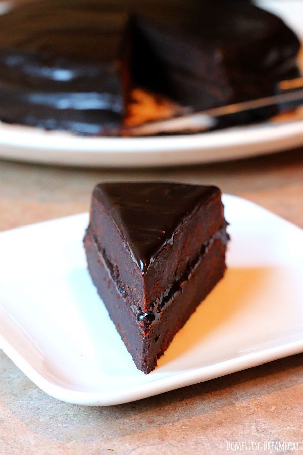 there is a piece of chocolate cake on the plate and another slice has been cut