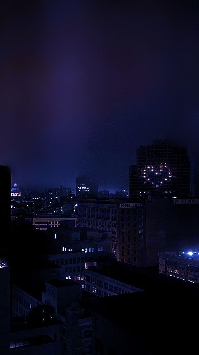 the city skyline is lit up at night with bright lights in the sky and buildings on both sides