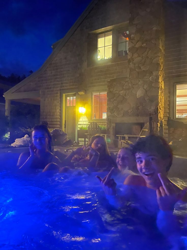 four people in a hot tub at night