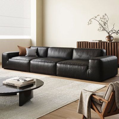 a modern living room with black leather furniture