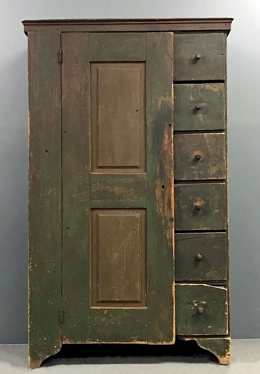 an old green wooden cabinet with drawers