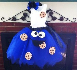 a dress made to look like cookie cookies is hanging on a fireplace mantel in front of a brick wall