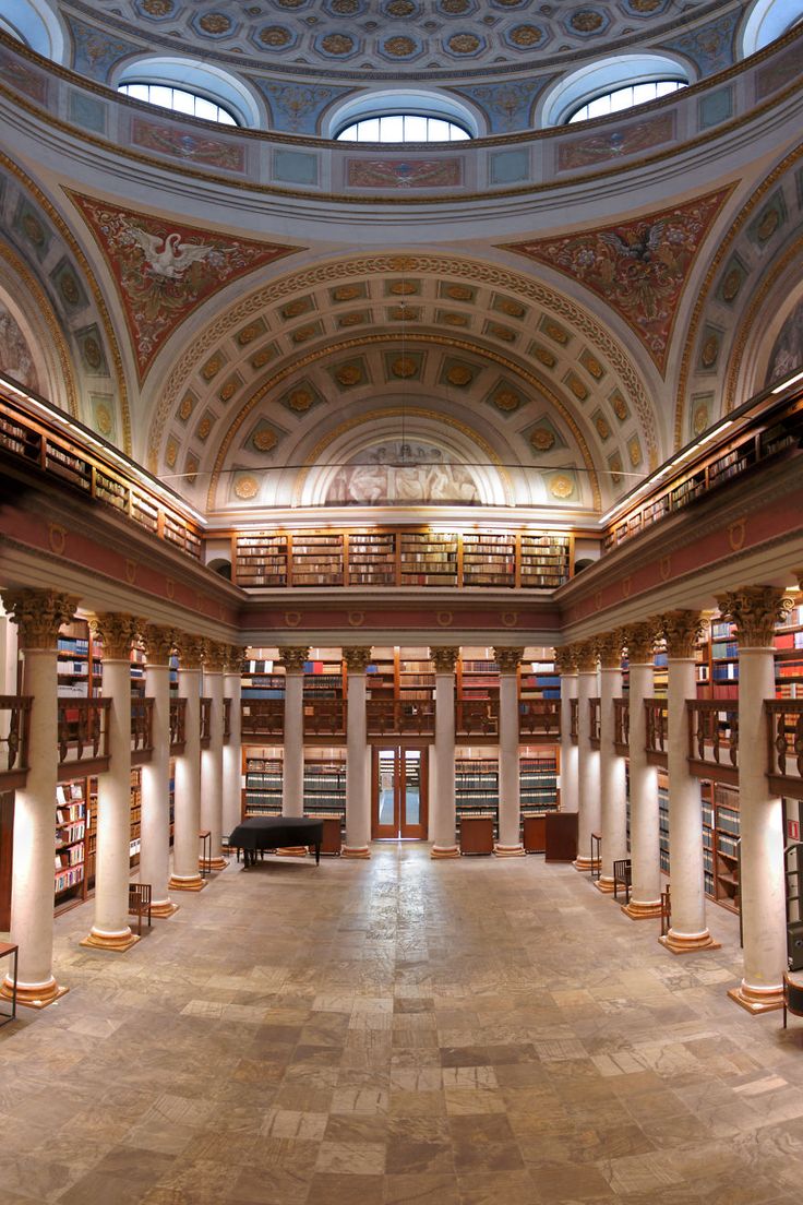 the inside of a large library with columns and bookshelves on either side of it