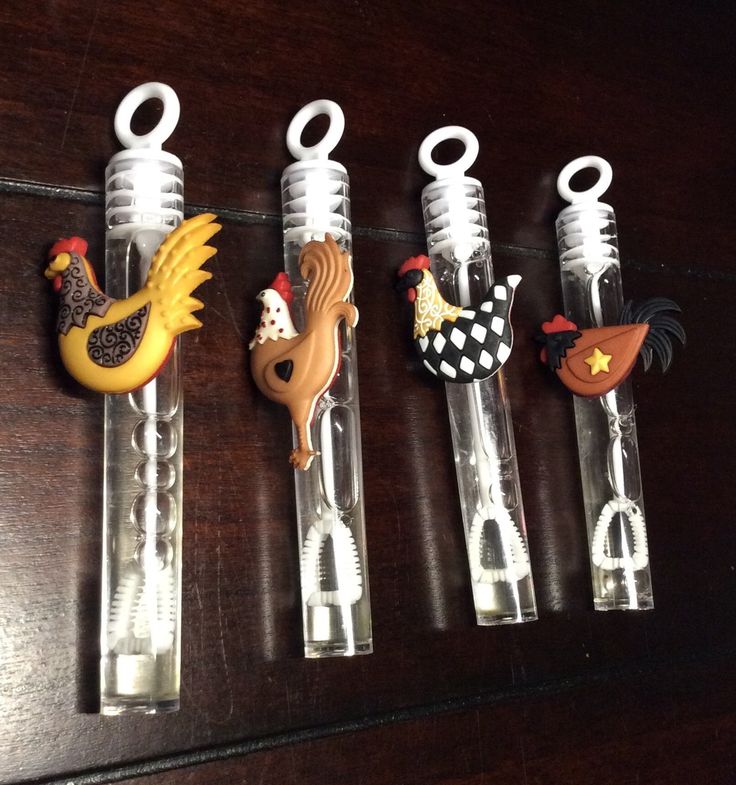 five plastic bottle openers with chicken, rooster and horse designs on them sitting on a table