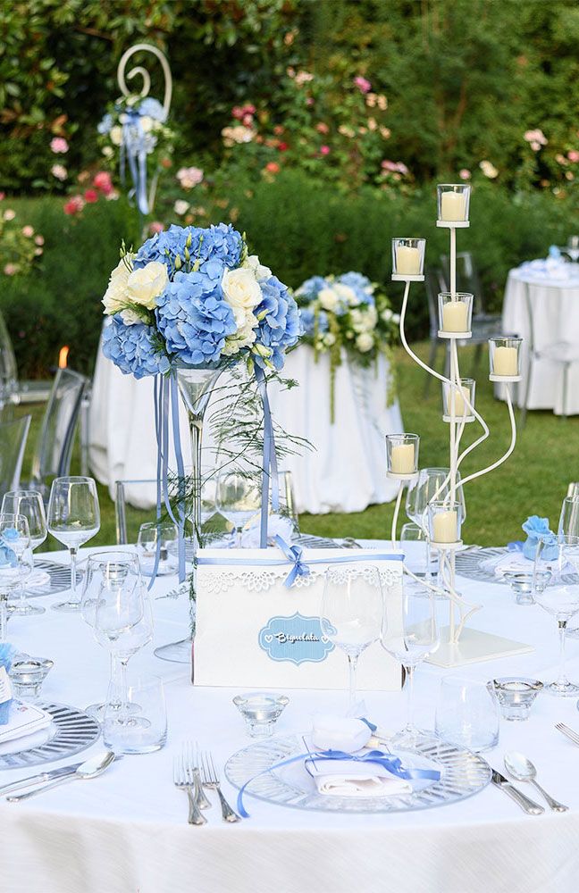 the table is set with blue and white flowers