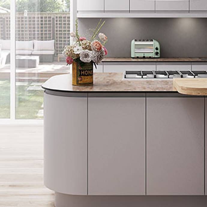 a kitchen with white cabinets and an island in the middle is seen from across the room