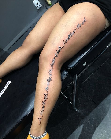 a woman sitting on top of a chair with her legs crossed and writing on the leg