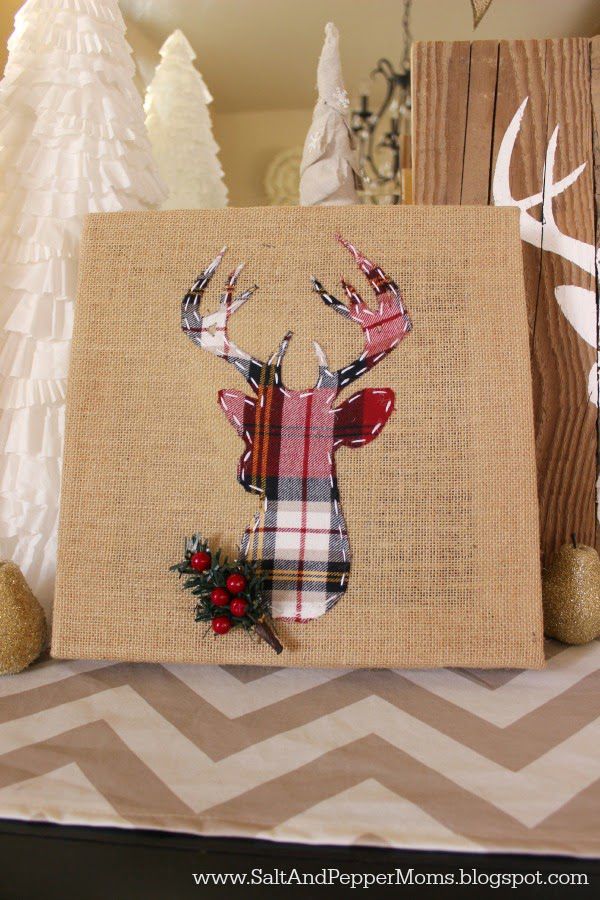 a canvas with a deer head on it sitting next to other christmas decorations and trees