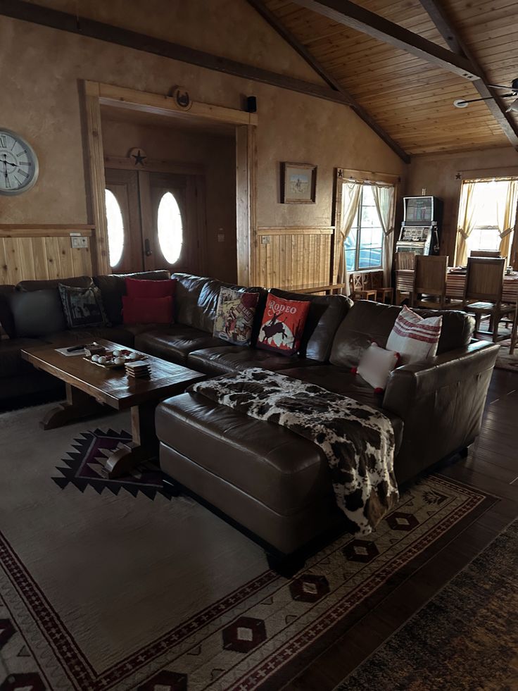 a living room filled with furniture and a large rug on top of a hard wood floor