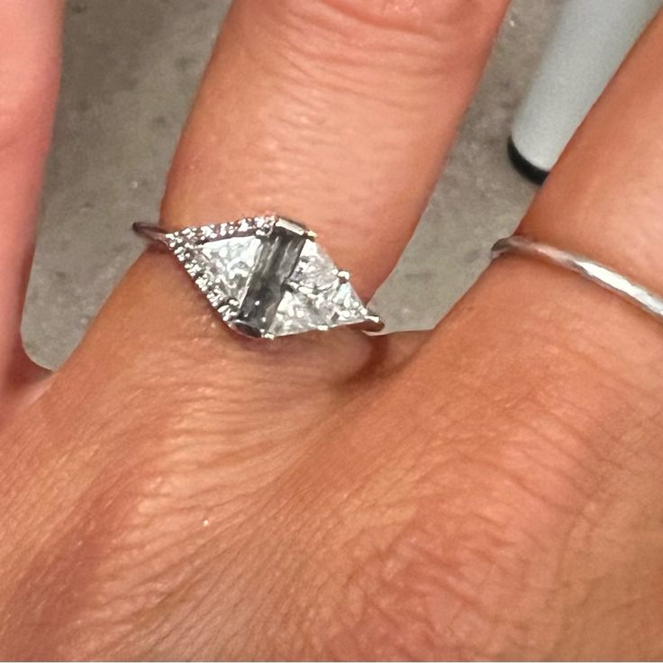 a woman's hand with a diamond ring on it