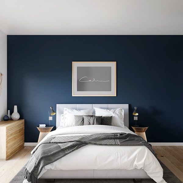 a bedroom with blue walls and white bedding in the center, along with two nightstands