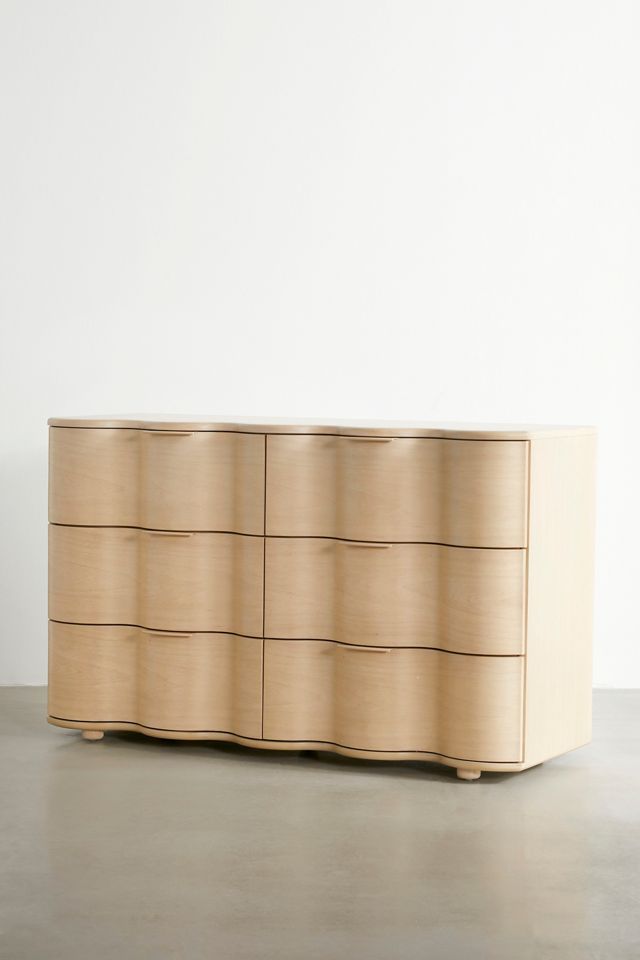 a large wooden dresser sitting on top of a cement floor next to a white wall