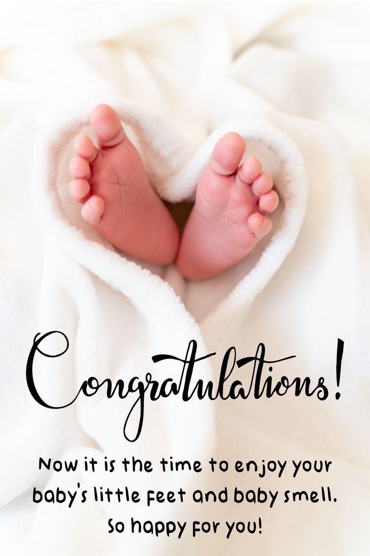 a baby's feet under a white blanket with congratulations written in black on it