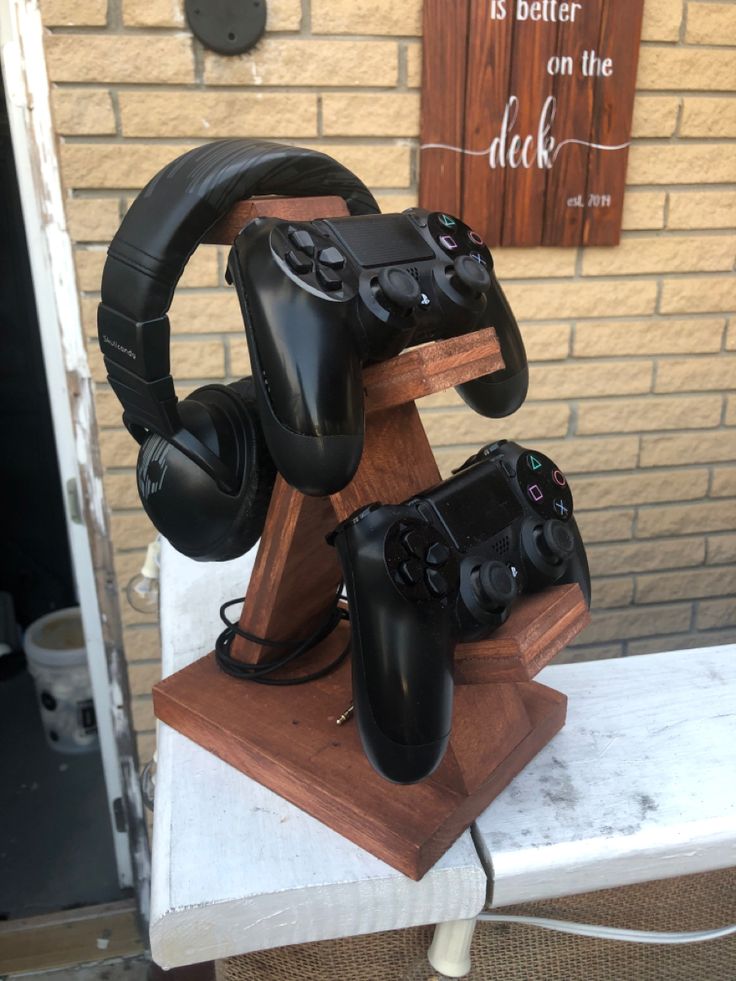 two video game controllers are stacked on top of each other in front of a brick wall