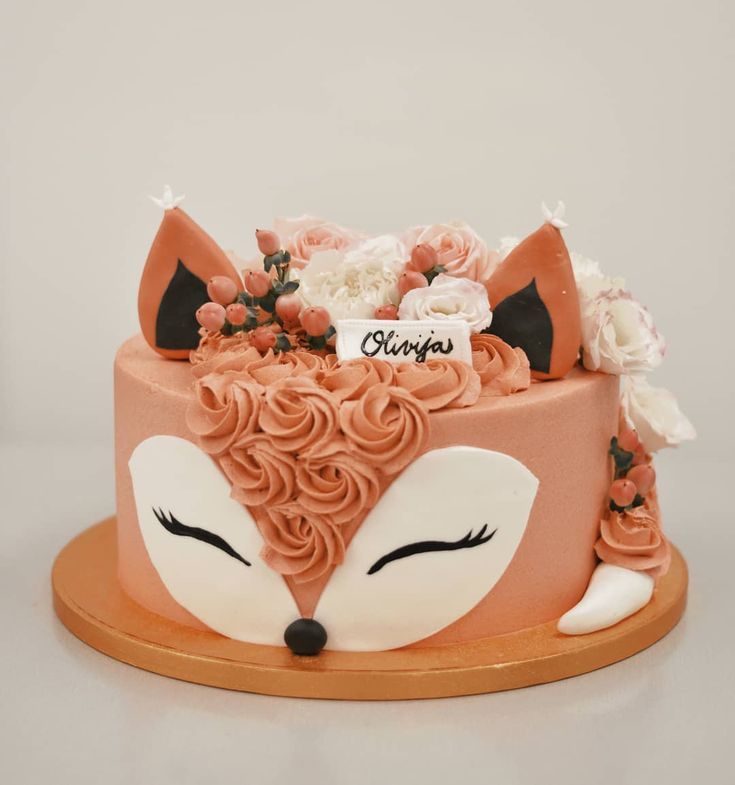 a cake decorated with flowers and a fox's head