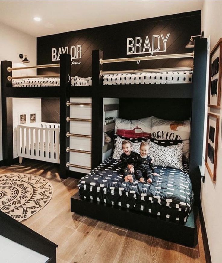 two children sitting on their bunk beds in a room with black and white decorating