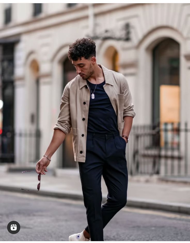 a man walking down the street with his foot on a skateboard in front of him