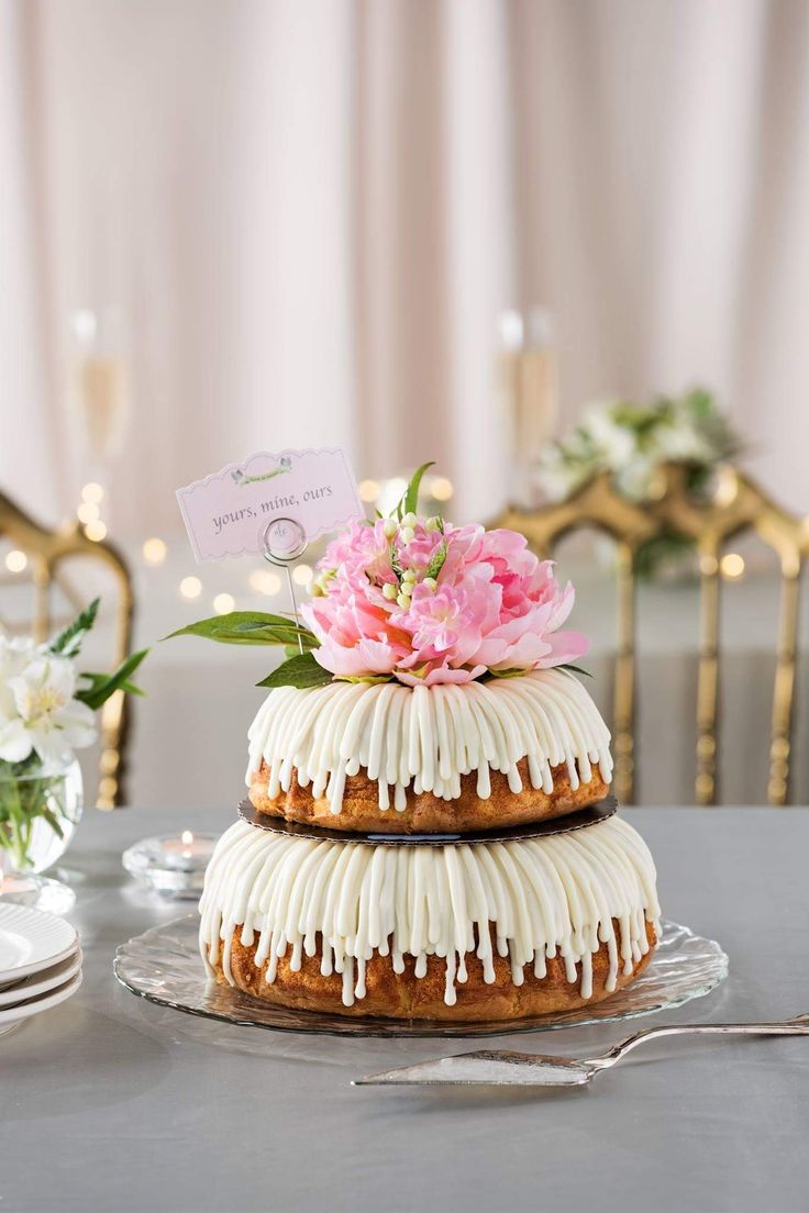 a three tiered cake sitting on top of a table next to plates and flowers