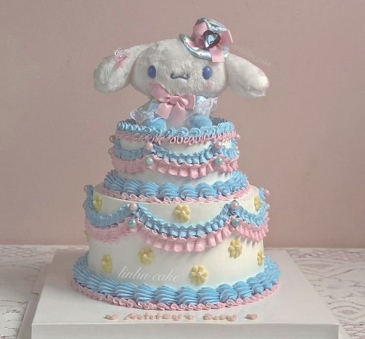 there is a cake that looks like a rabbit on top of the cake, and it's made out of fondant