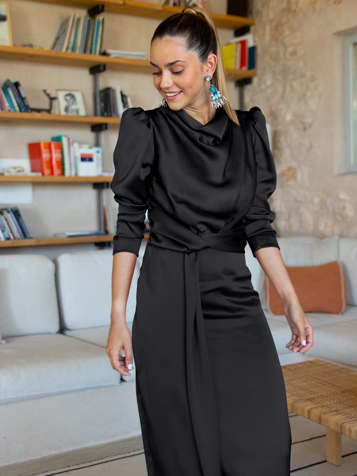 Introducing the timelessly elegant Ximena Satin Long Sleeve Midi Dress. With its classy black tone satin fabric, this sophisticated and sleek piece is perfect for making an impression at any special occasion. Its high-quality material offers a luxe silk-like feel, while the midi length and long sleeves offer modest sophistication. An enduringly elegant look. Size Guide: Model is 5’7” tall, and has a 33.4” bust, 26.5” waist, & 34.6” hips. She is wearing a S / US 4 / AU 8. This dress is true to si Silk Satin Dress With Sleeves, Knotted Maxi Dress, Satin Cowl Neck Dress, Black Long Sleeve Midi Dress, Satin Long Sleeve, Cowl Neck Dress, Silk Robe, Dress Satin, Sleeve Midi Dress