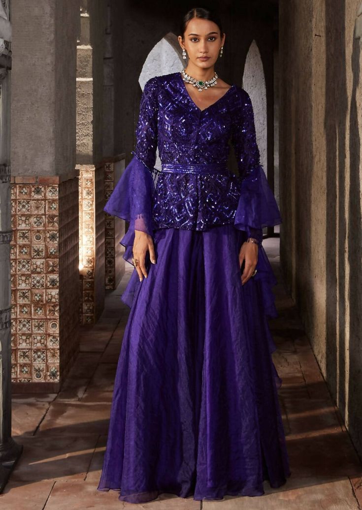 This gorgeous purple sharara with full sleeves has geometric embroidery with front open. It is paired with organza sharara. The outfit is completed with frill dupatta and belt. Purple Palazzo Set With Sheer Dupatta For Diwali, Bollywood Style Ruffled Palazzo Set For Party, Eid Party Palazzo Set With Ruffles, Elegant Purple Palazzo Set For Festive Occasions, Designer Purple Organza Sharara, Eid Party Anarkali Set With Ruffles, Designer Long Sleeve Purple Palazzo Set, Party Organza Palazzo Set With Long Sleeves, Long Sleeve Organza Palazzo Set For Parties