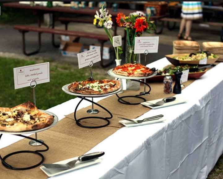 a table topped with lots of pizzas on top of trays next to each other