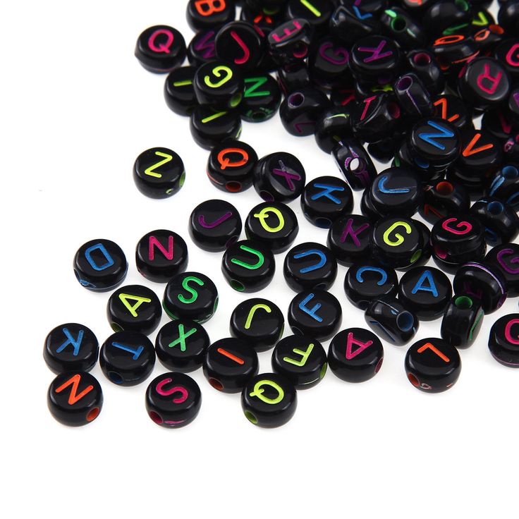 black and multicolored letters are scattered on a white surface